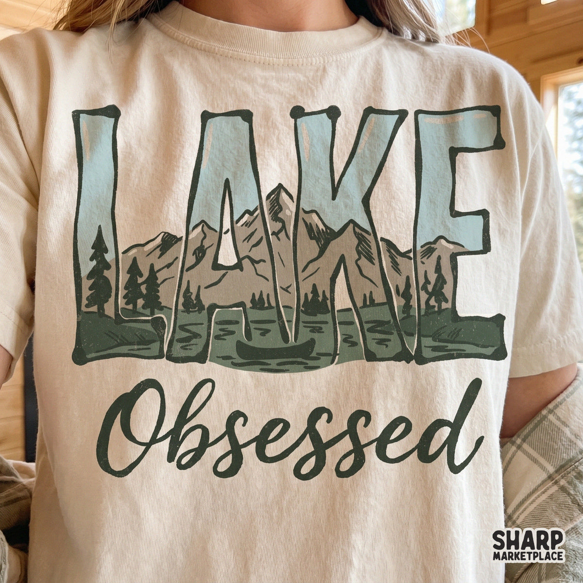 Rustic Lake Obsessed sublimation design with a mountain, lake, and canoe scene, perfect for creating custom tumblers, stickers, and outdoor apparel.