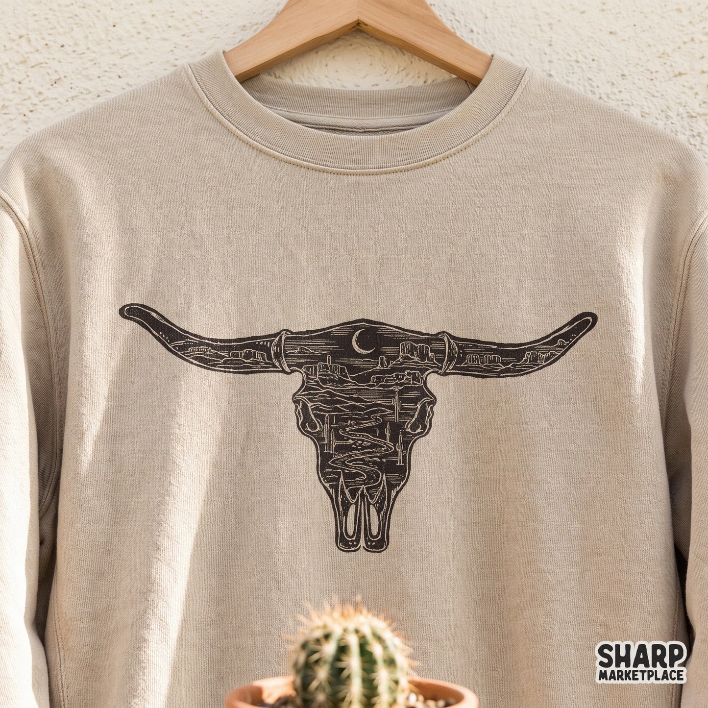 Vintage western bull skull illustration with a desert landscape and cacti for country music shirts and cowboy decor
