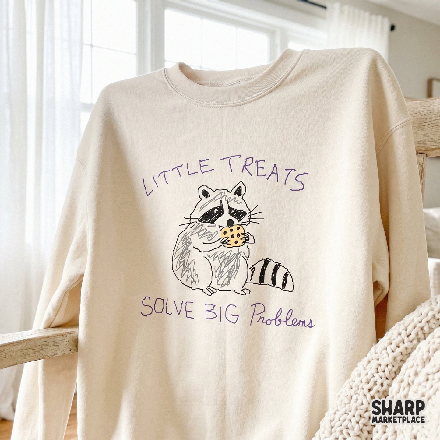 Whimsical raccoon illustration with a cookie and the quote Little Treats Solve Big Problems, a funny mental health humor design for printable crafts.