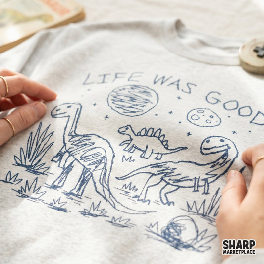 Blue monochromatic line art of dinosaurs under a starry sky with a moon and planet, ideal for custom t-shirt printing and DIY projects.