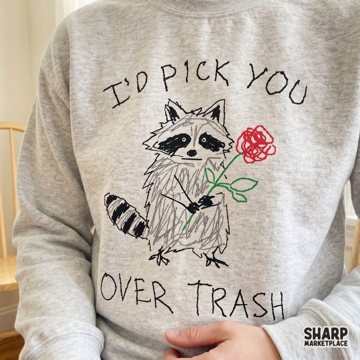 Quirky hand-lettered design with a sketchy raccoon holding a flower, ideal for DIY gifts, funny valentines, or custom apparel and sublimation projects.