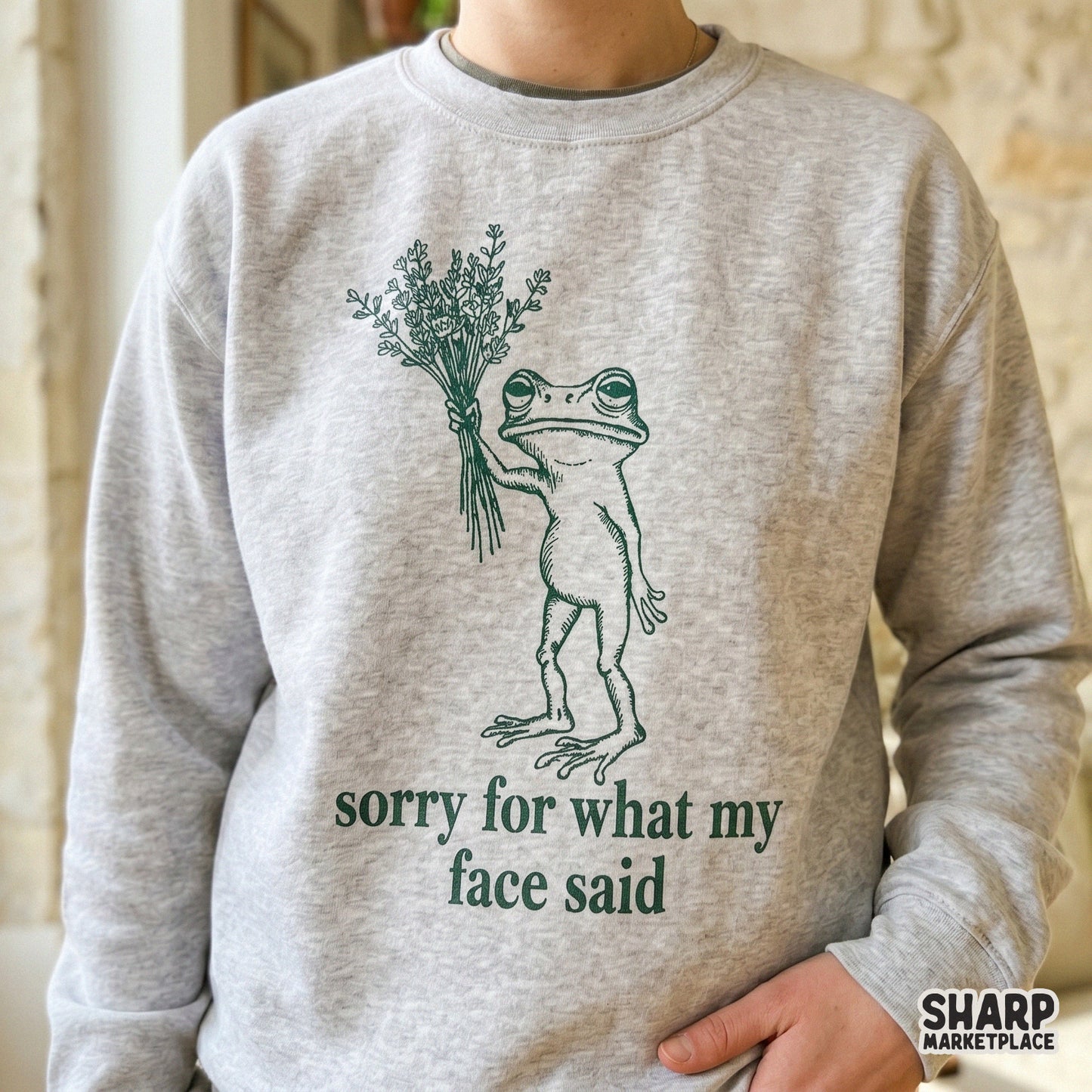 Whimsical frog graphic with a bouquet and the witty phrase sorry for what my face said, designed for print-on-demand apparel, tumblers, and DIY gifts.