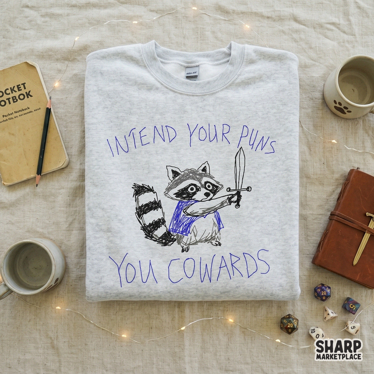 Whimsical raccoon knight illustration with a blue cape and sword, perfect for sublimation or shirt printing, featuring the text Intend Your Puns You Cowards.