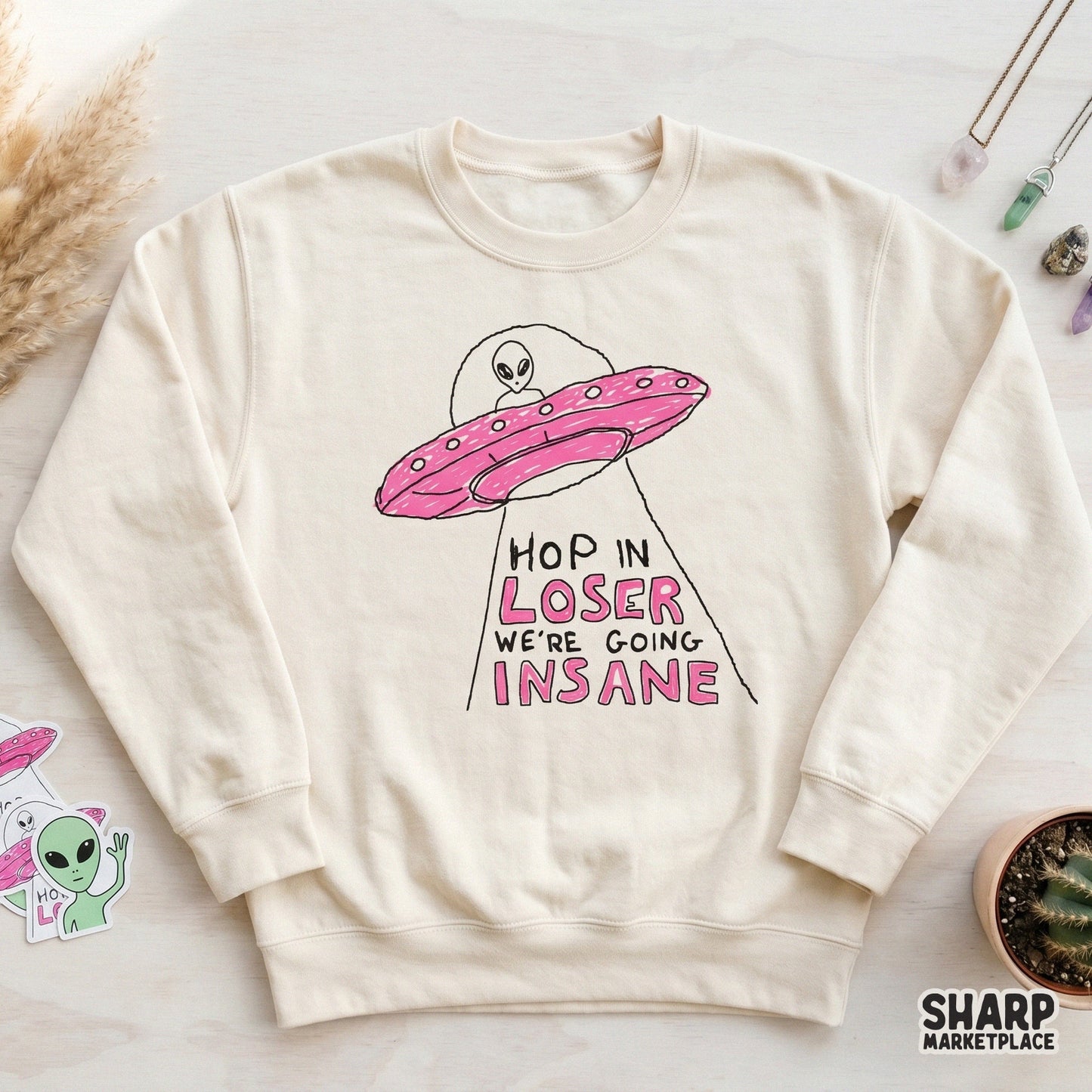 Funny extraterrestrial doodle design with a pink flying saucer, perfect for y2k-style aesthetic projects, stickers, and custom clothing prints.