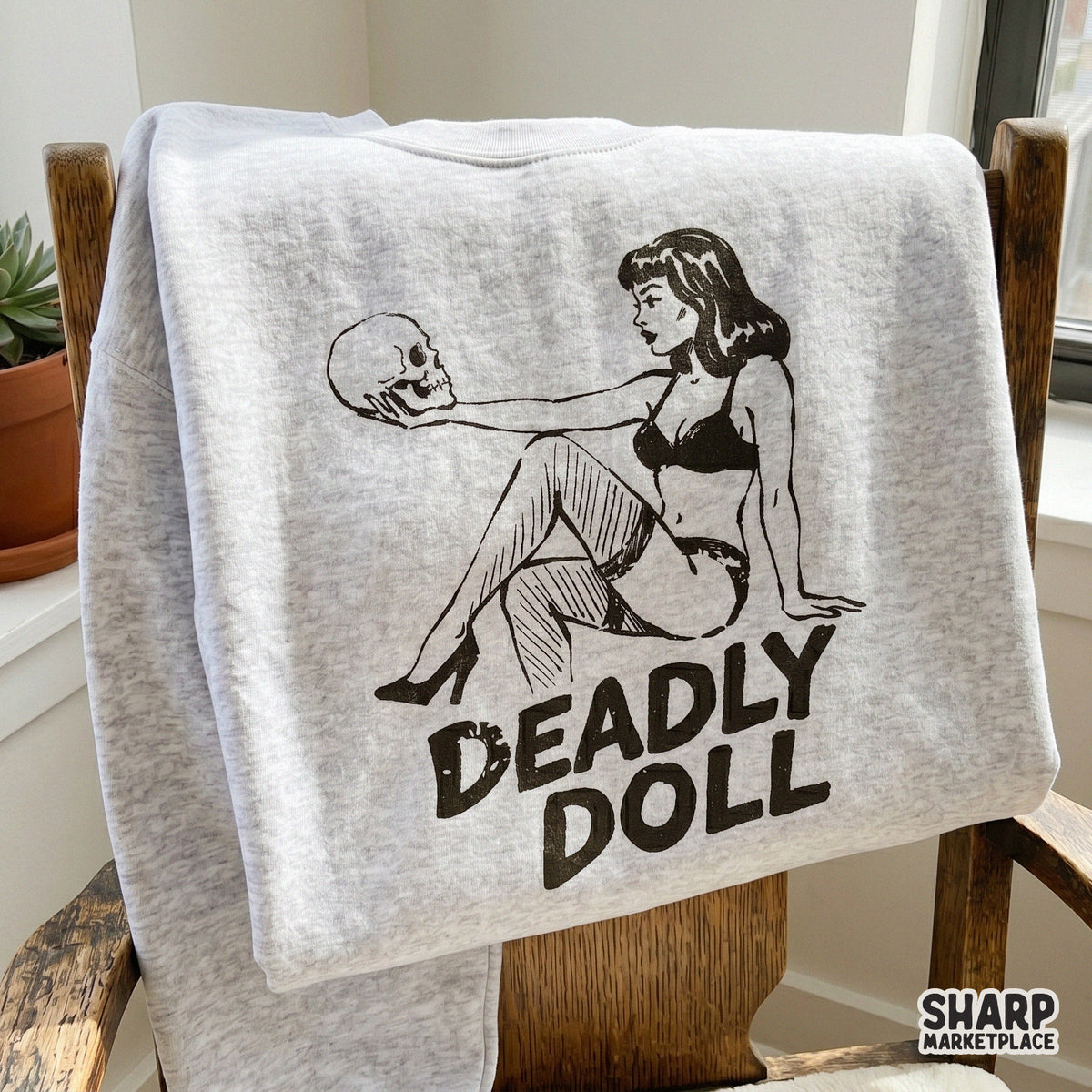 Retro horror pinup design featuring a woman with a skull and the text Deadly Doll for custom gothic t-shirts and spooky sticker projects.