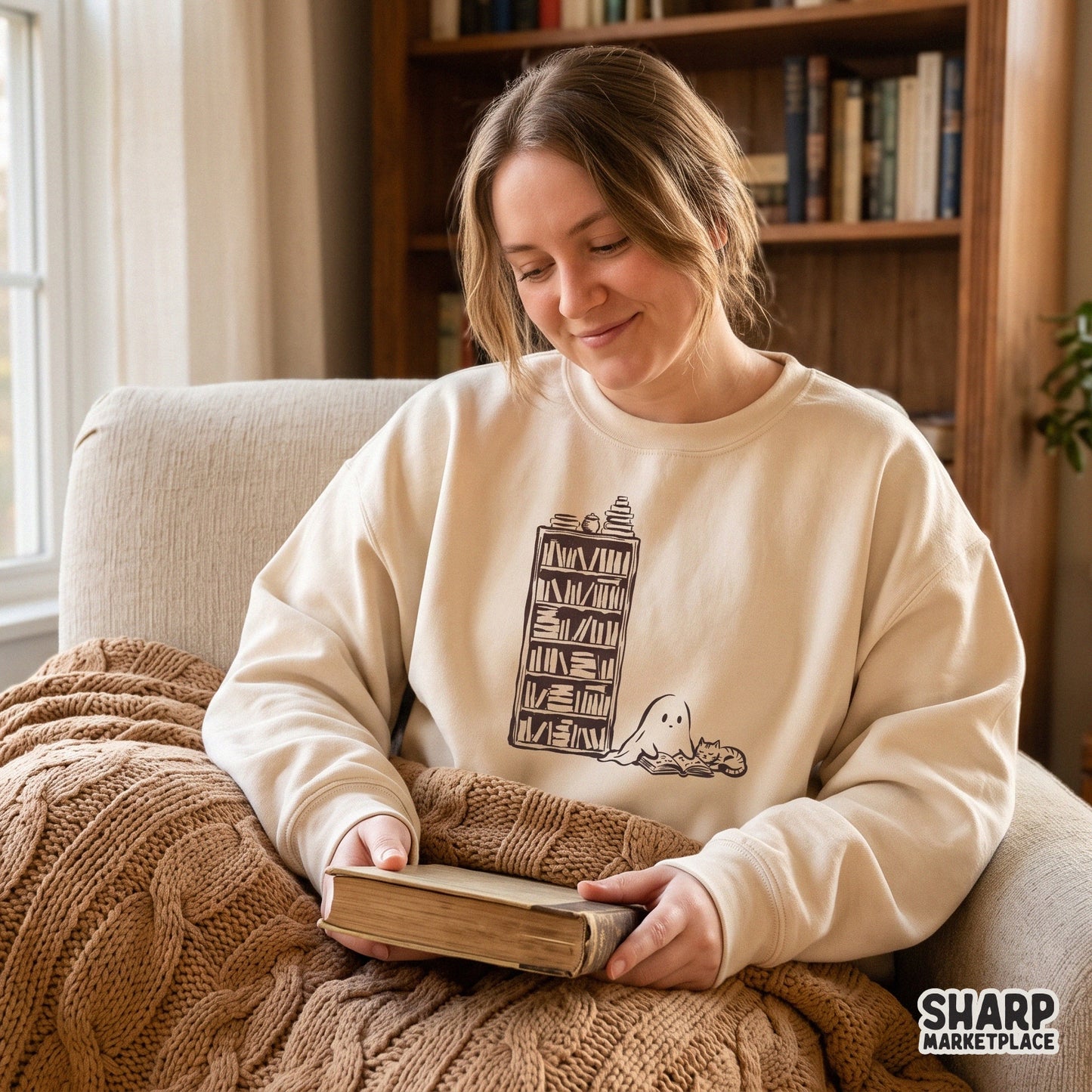 Cute ghost reading a book by a bookshelf with a cat cozy spooky season halloween png design for autumn t-shirts