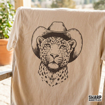 Detailed black and white leopard portrait in a cowboy hat printed on a beige t-shirt, perfect for western-themed sublimation and apparel.
