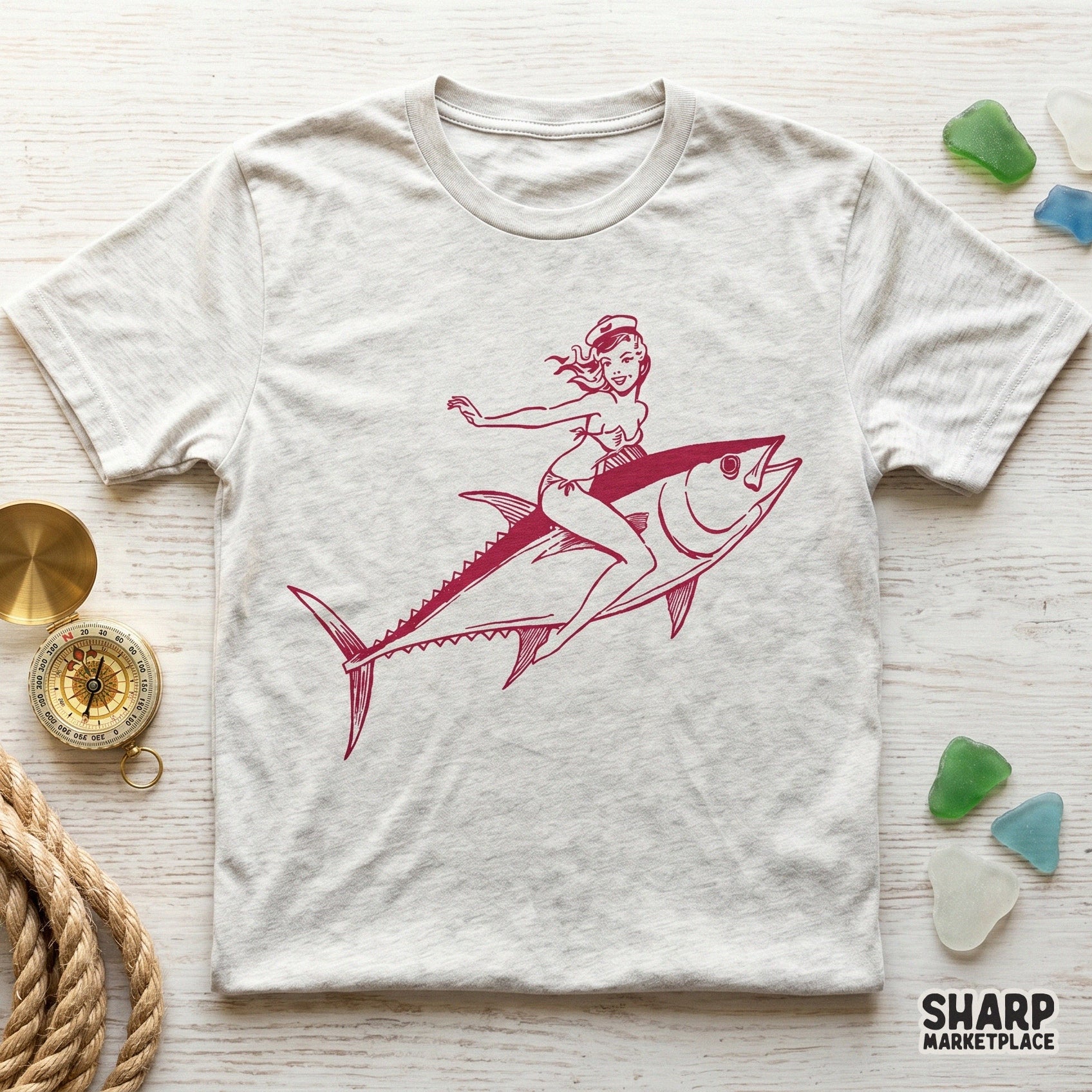 Detailed red line art graphic featuring a pinup girl riding a tuna fish, suitable for coastal themed wall art, custom clothing, and summer accessories.