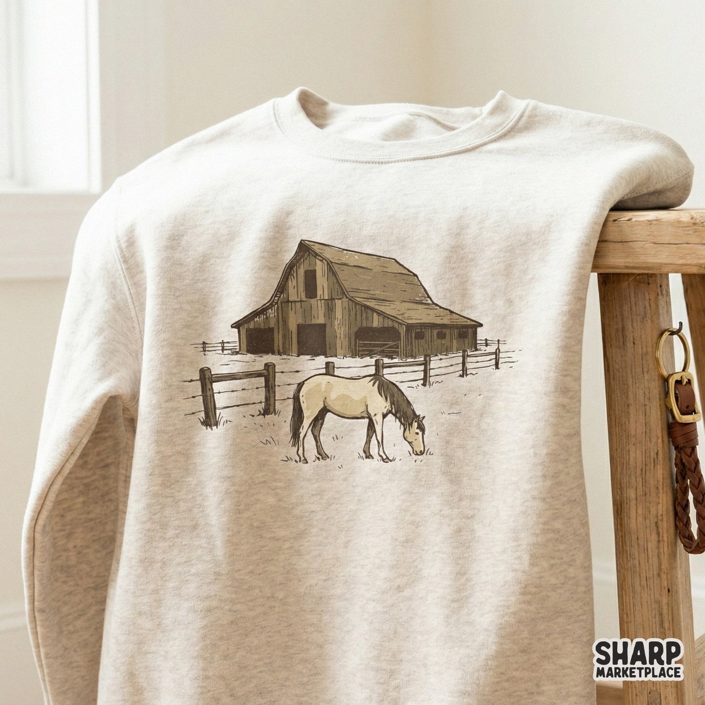 Detailed digital illustration of a wooden stable and grazing horse with a post-and-rail fence, ideal for western shirts and home decor.