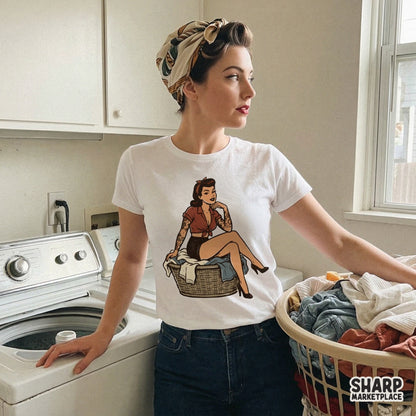 Vintage rockabilly pin up girl graphic with traditional tattoos, wearing high heels and sitting on a woven laundry basket, isolated on a light background.