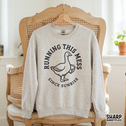 Vintage-inspired goose illustration with a clipboard, designed for sublimation or apparel, featuring the humorous quote Running This Mess Since Sunrise.