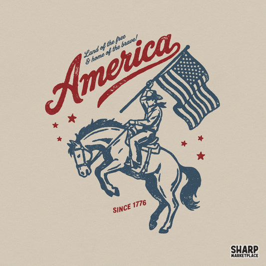 Vintage patriotic design featuring a cowboy on a bucking horse holding an American flag with the text America and Land of the free and home of the brave.