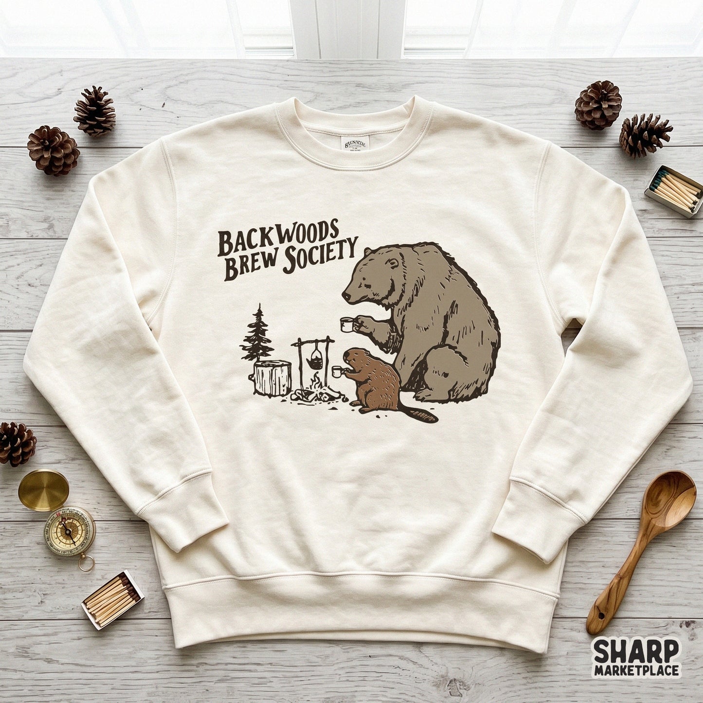 Digital sublimation design of a bear and beaver camping scene with coffee mugs and a campfire, perfect for rustic apparel or outdoor gear.