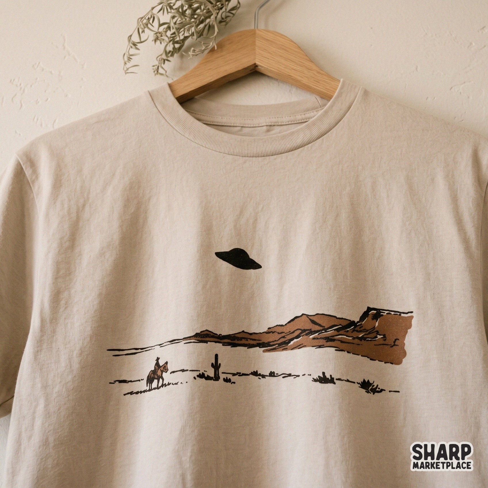 Vintage style western desert graphic with a lone cowboy and alien spacecraft, perfect for trendy t-shirt designs, stickers, or unique wall art prints.