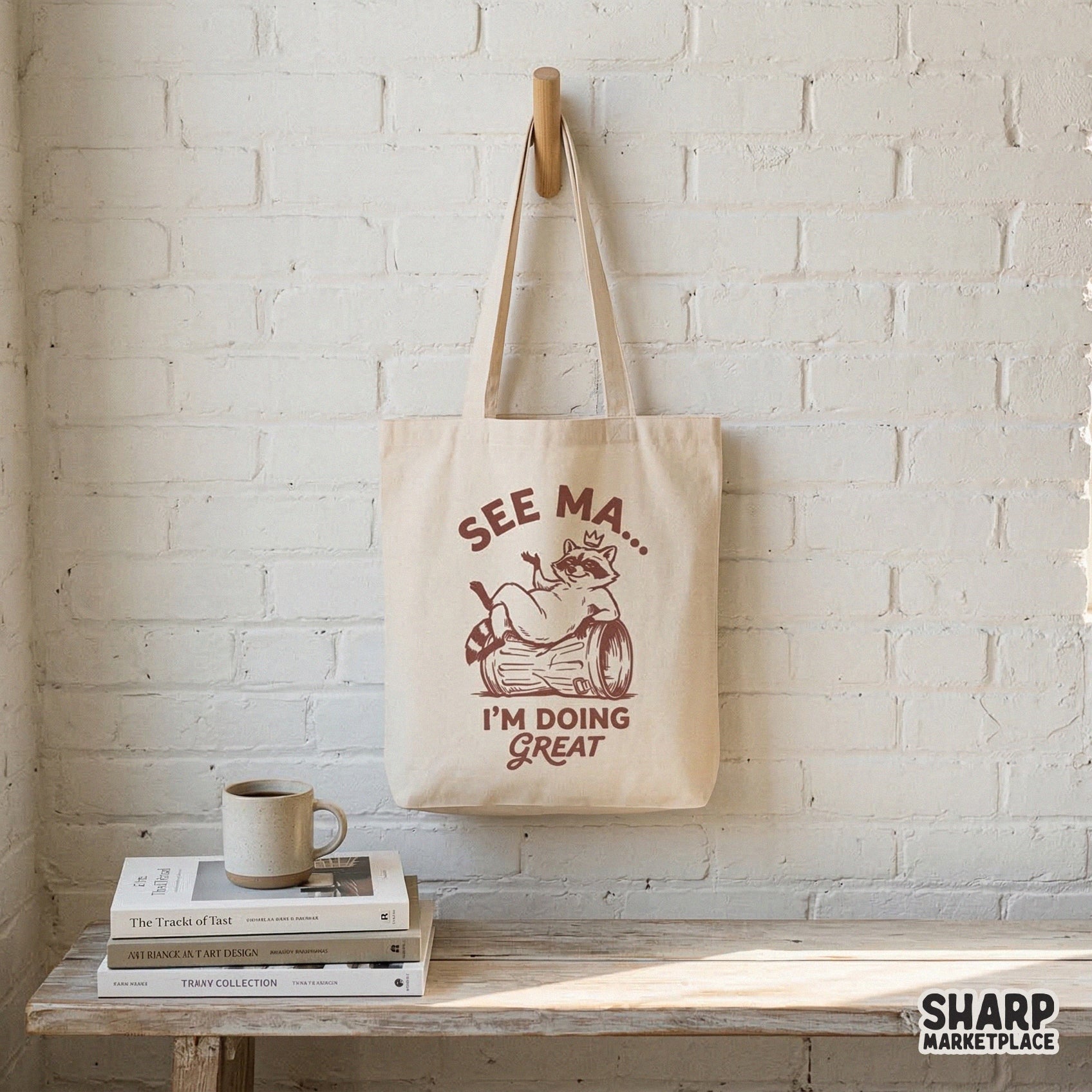 Tote bag featuring a vintage style brown raccoon wearing a crown while lounging on a garbage can with the sarcastic quote See Ma I'm Doing Great.
