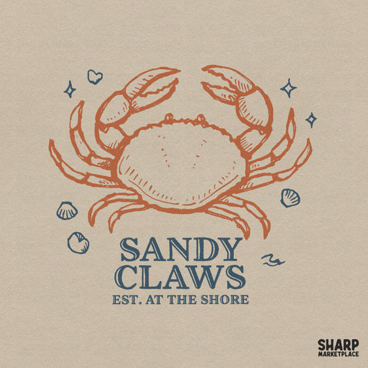 Hand-drawn terracotta crab illustration with blue text reading Sandy Claws Est. at the Shore, accented by seashells and stars for summer apparel.