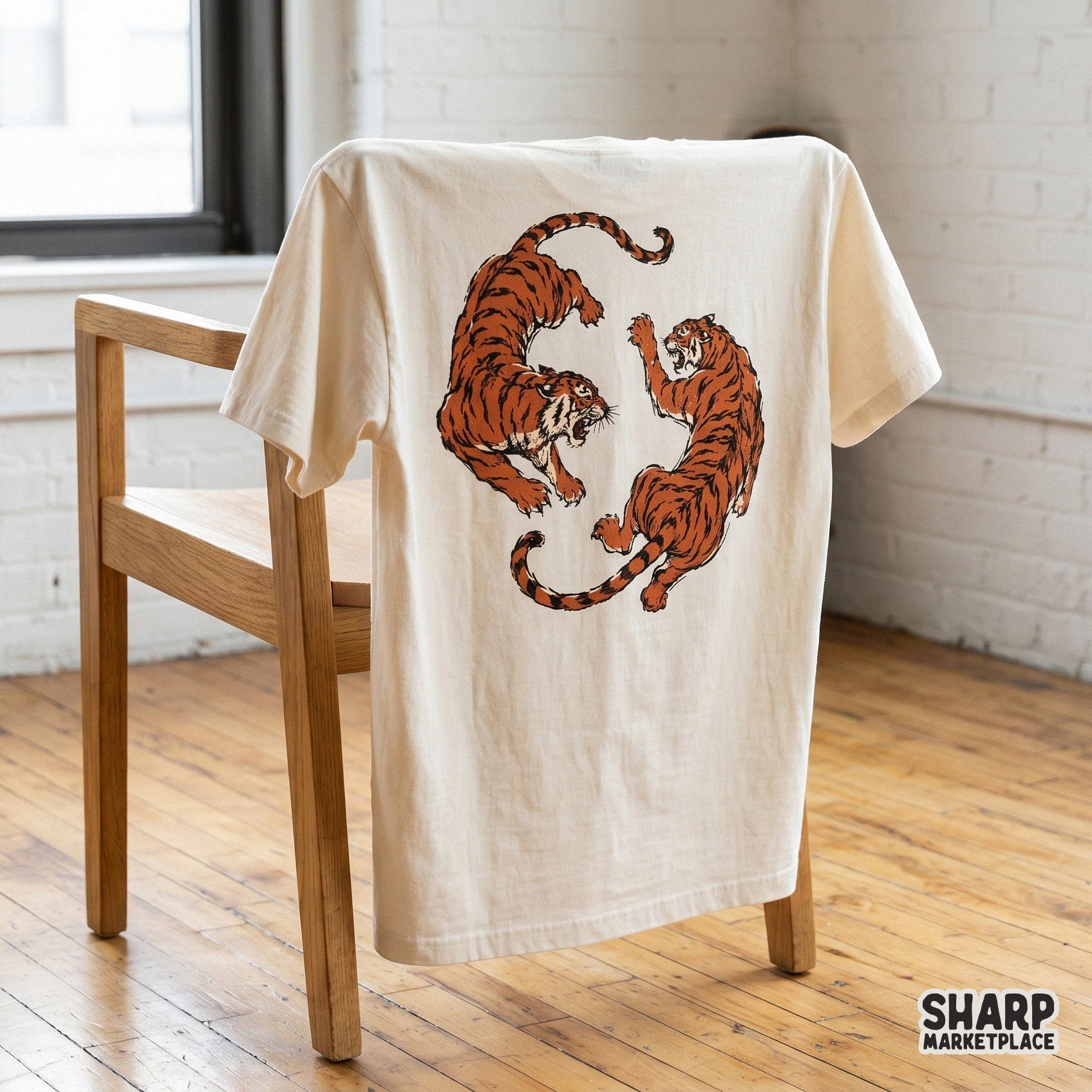 Two snarling tigers arranged in a circular mirrored pose, featured as a retro tattoo style graphic on a cream colored t-shirt mockup.