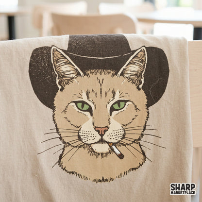 Retro-style cowboy cat graphic featuring a tough feline in a western hat and cigarette, printed on a fabric surface for custom apparel projects.
