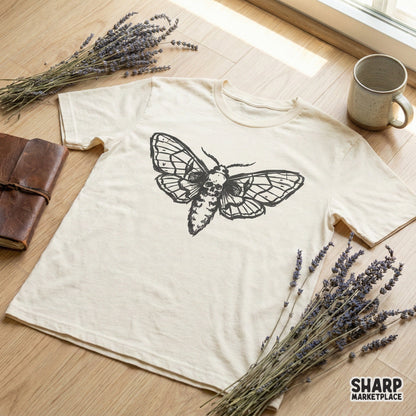 Gothic moth and skull design printed on a neutral-colored t-shirt, showcasing the bold black ink artwork suitable for apparel and sublimation.