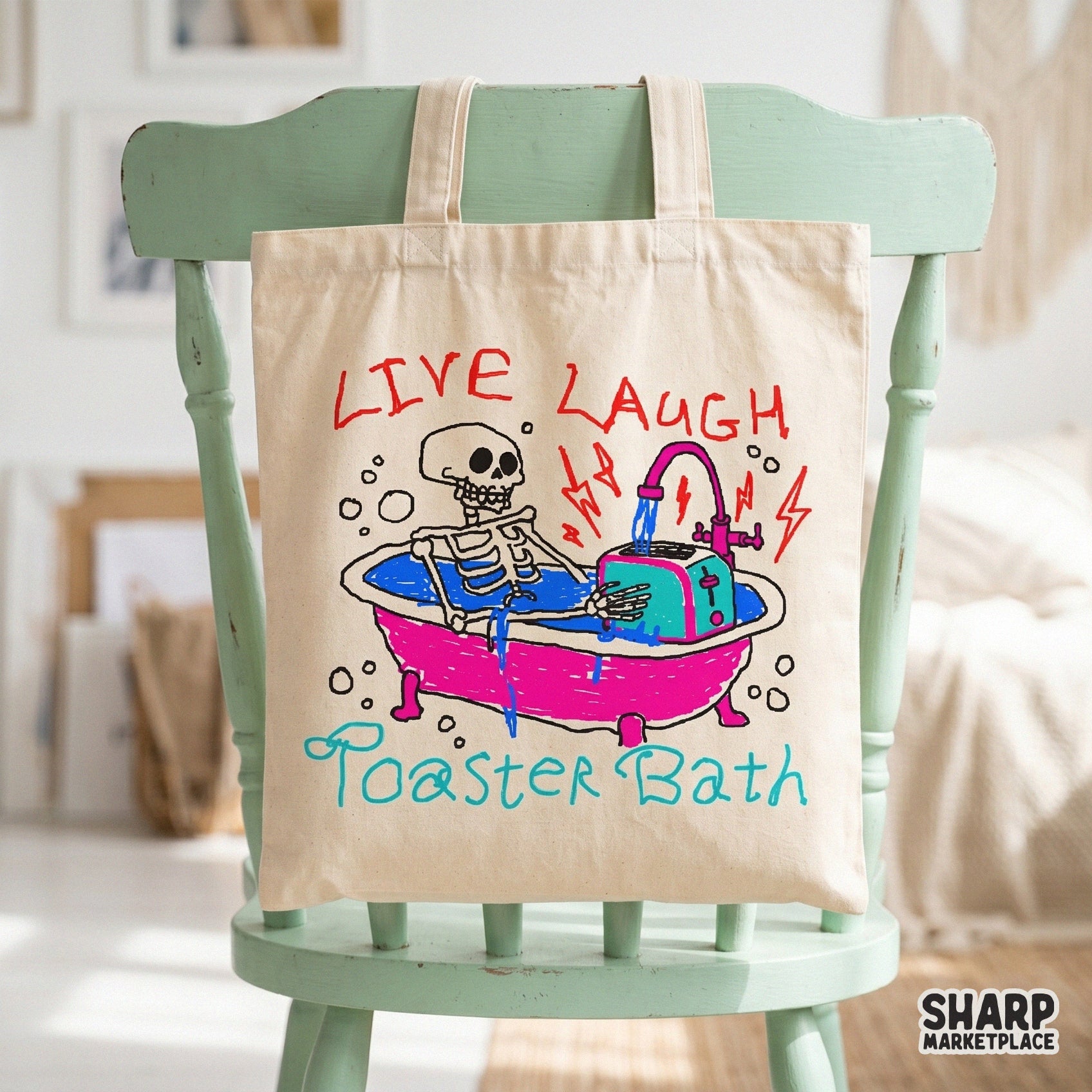 Tote bag mockup displaying a dark humor illustration of a skeleton in a bathtub with a toaster, accented by neon colors and crayon-style lettering.