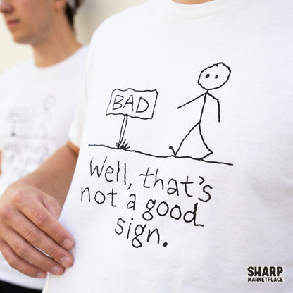 Simple black line art illustration of a stick figure passing a sign that says BAD with the sarcastic caption Well, that is not a good sign.