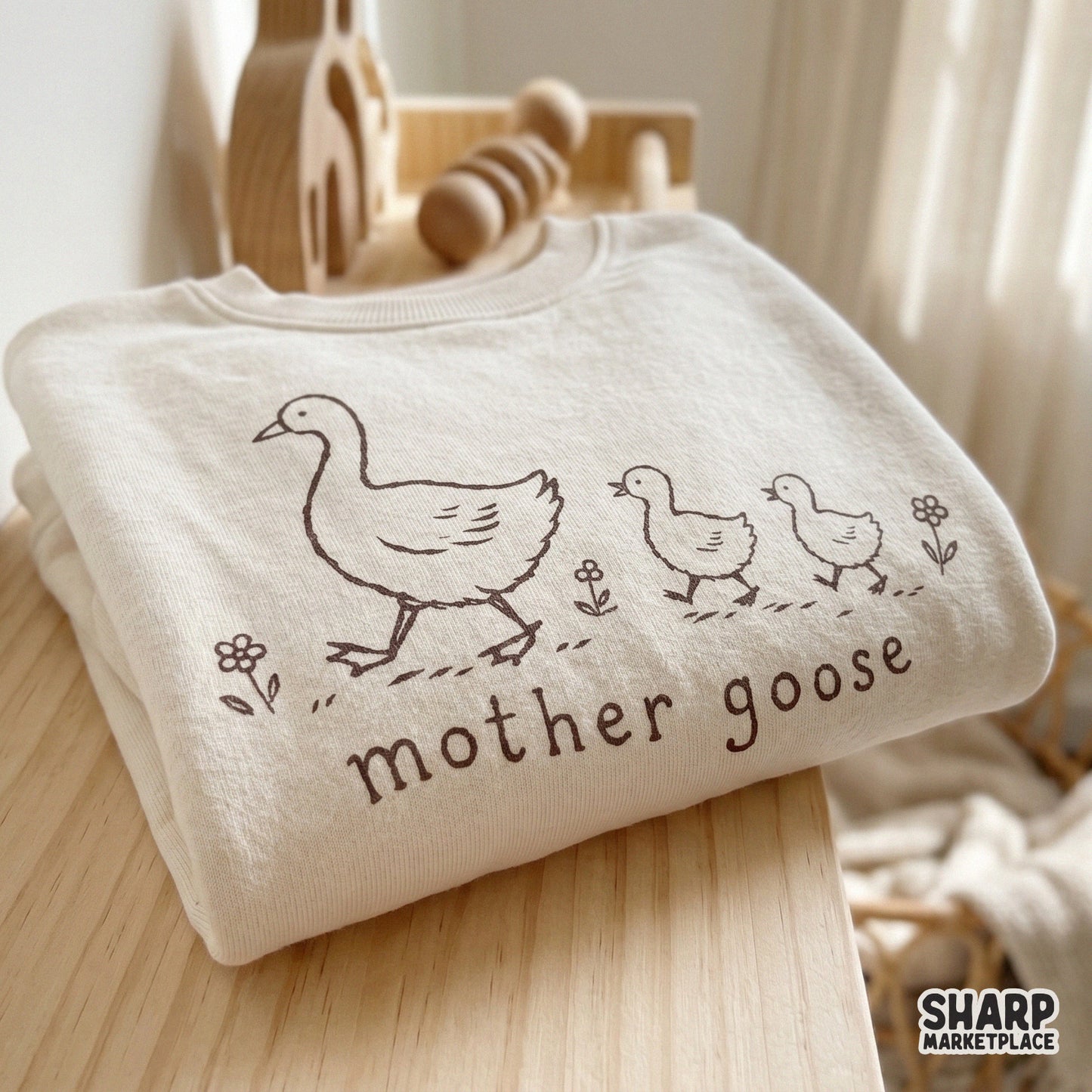 A cozy cream-colored sweatshirt featuring a brown line art design of a mother goose and her babies, ideal for custom children's apparel.