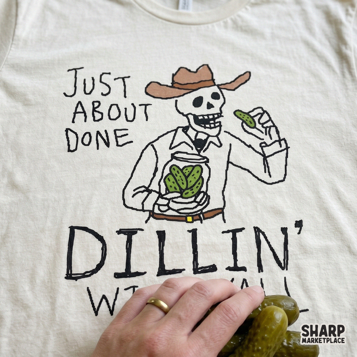 Sarcastic western digital art of a skeleton cowboy enjoying a pickle, perfect for custom t-shirts, stickers, or tumblers with a rustic aesthetic.