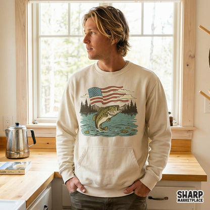 Patriotic fishing design featuring a jumping bass and American flag, shown as a graphic print on a casual cream colored crewneck sweatshirt for apparel.