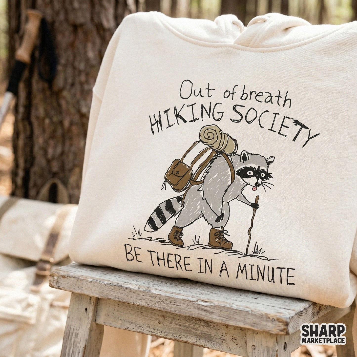 Funny outdoor-themed digital graphic showing a raccoon with a walking stick and the quote Out of Breath Hiking Society, suitable for print-on-demand items.