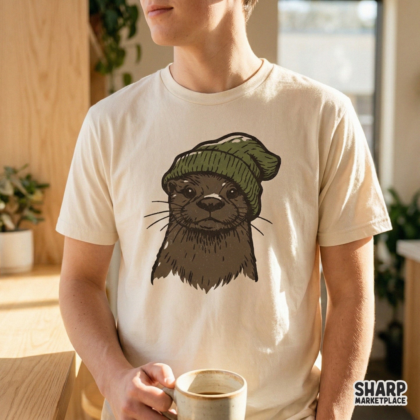 Digital design of an adorable otter in a cozy green winter hat, showcased on a light-colored t-shirt for a trendy woodland-inspired look.