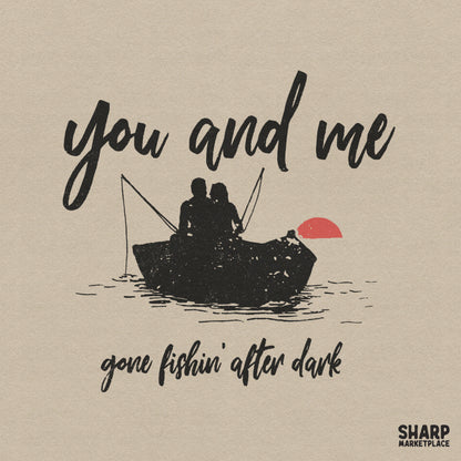 Retro fishing design featuring a silhouette of a couple in a boat under a red sun with the text You and me gone fishin' after dark in script font.