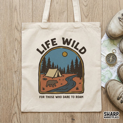 Tote bag mockup displaying a retro outdoor adventure graphic with a bear, forest, and tent, featuring the motivational text Life Wild.