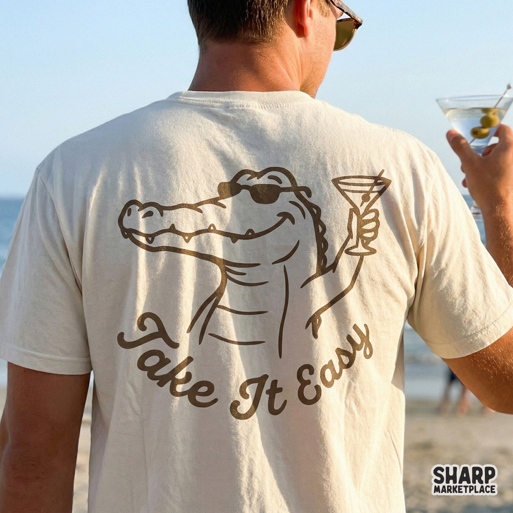 Trendy summer graphic design of a cool reptile with a drink and the quote Take It Easy, suitable for DIY printing on tumblers, shirts, or posters.