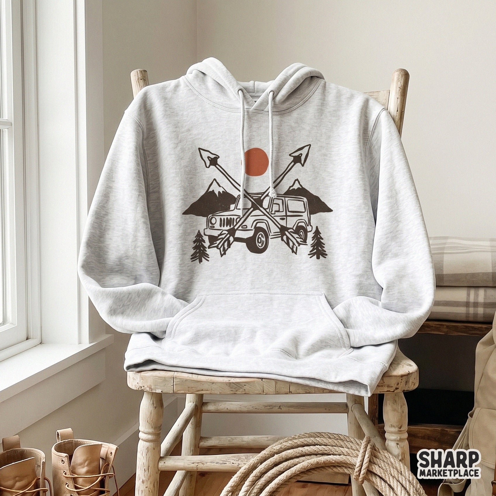 Vintage-style 4x4 adventure graphic with pine trees and crossed arrows displayed on a light gray hooded sweatshirt for a custom apparel mockup.