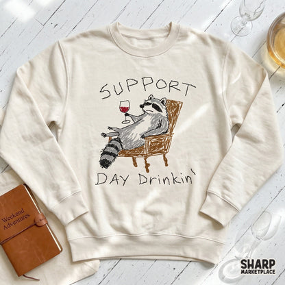Support Day Drinkin graphic featuring a whimsical raccoon sketch, ideal for custom t-shirt printing, stickers, and sarcastic wine-themed sublimation art.