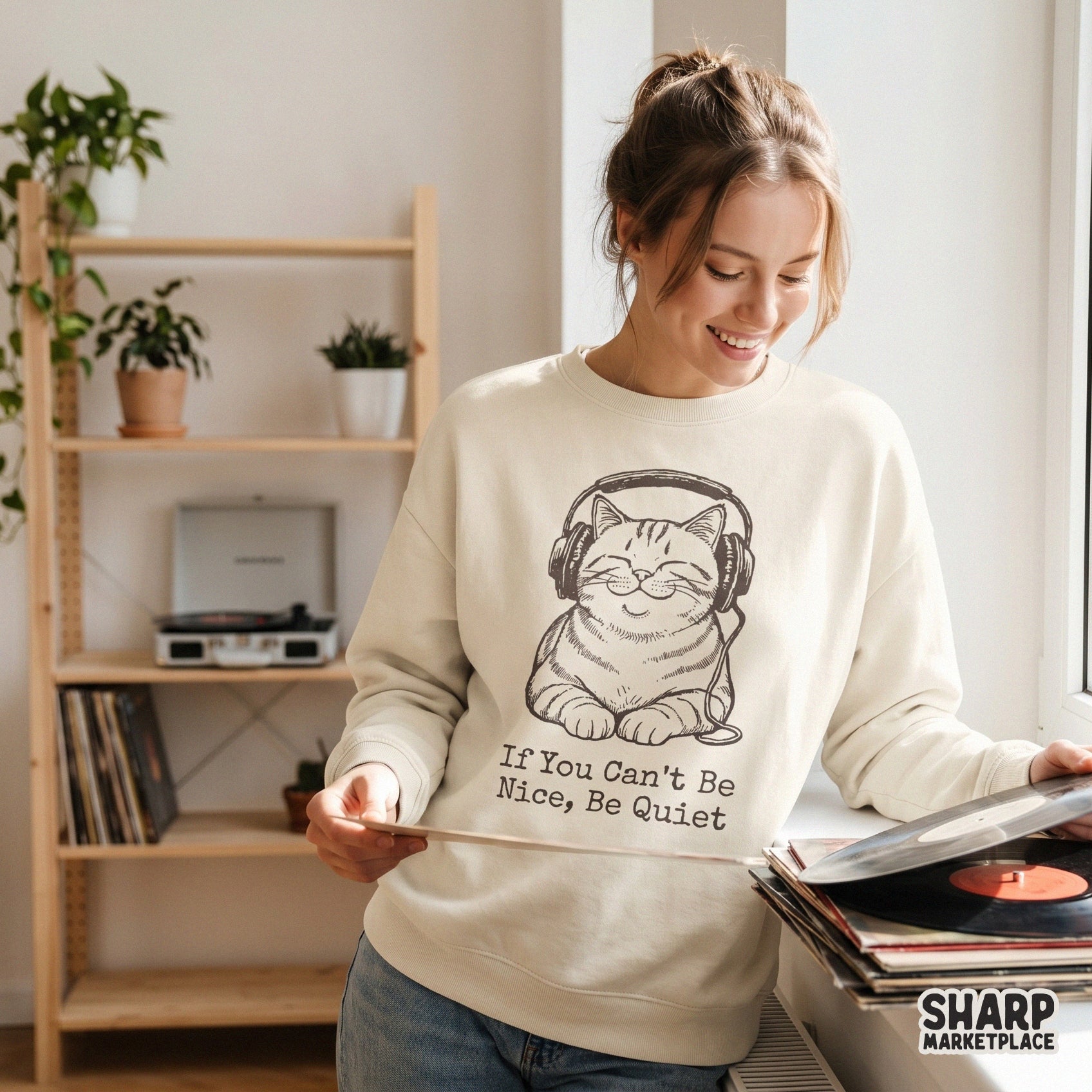 Monochromatic illustration of a serene cat listening to music with the witty phrase If You Can't Be Nice, Be Quiet for custom stickers or shirts.