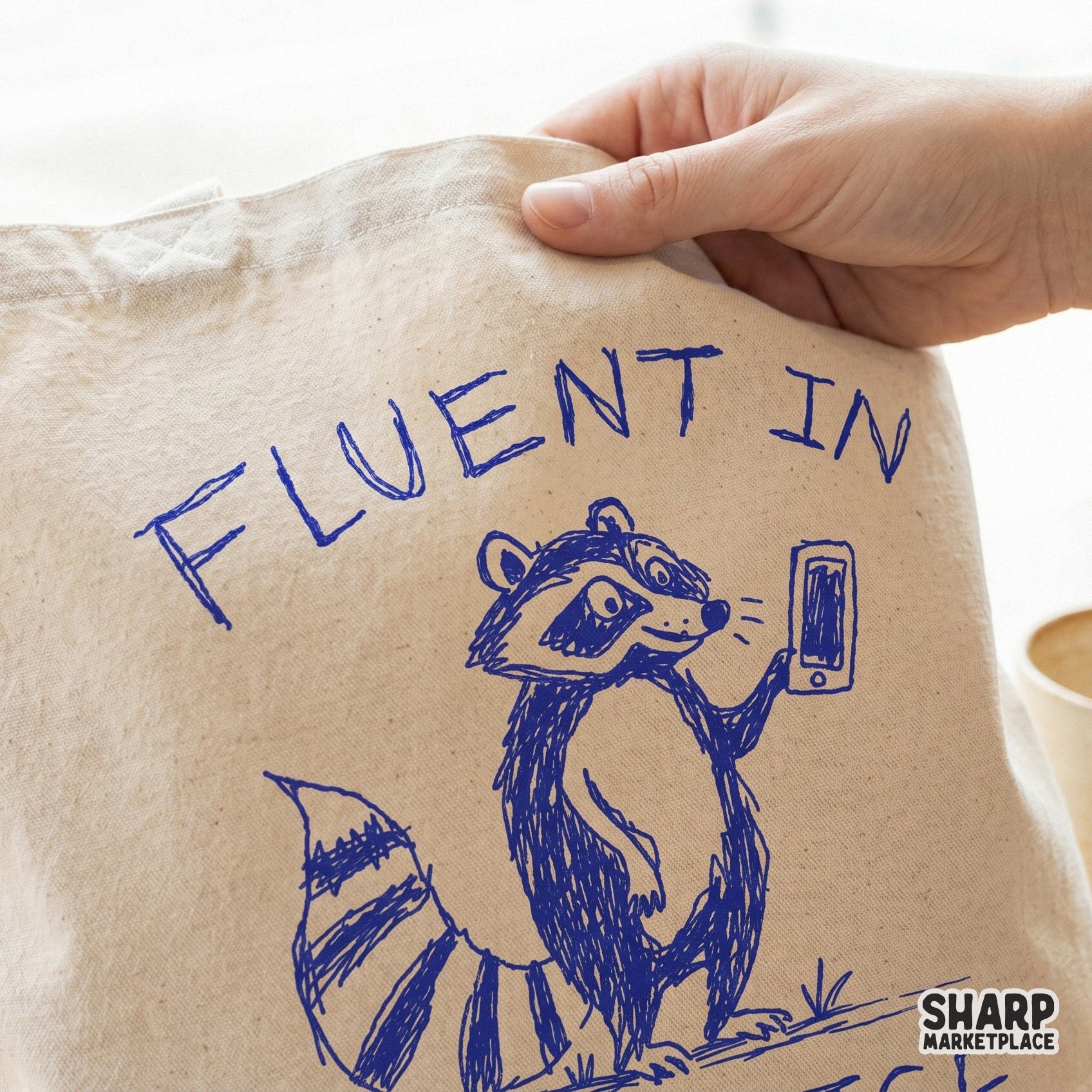 Whimsical blue line art of a raccoon on a phone, designed as a transparent PNG for custom t-shirts, sublimation projects, and trendy DIY gifts.