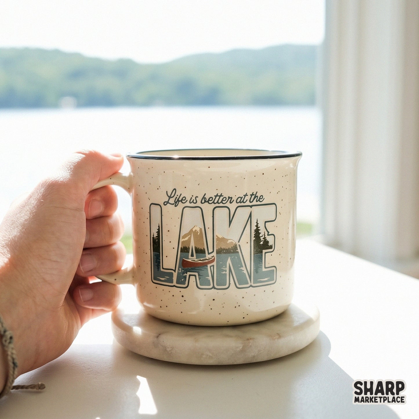 Ceramic mug featuring a vintage lake landscape design with a canoe, mountains, and trees inside the word LAKE, with the quote Life is better at the.