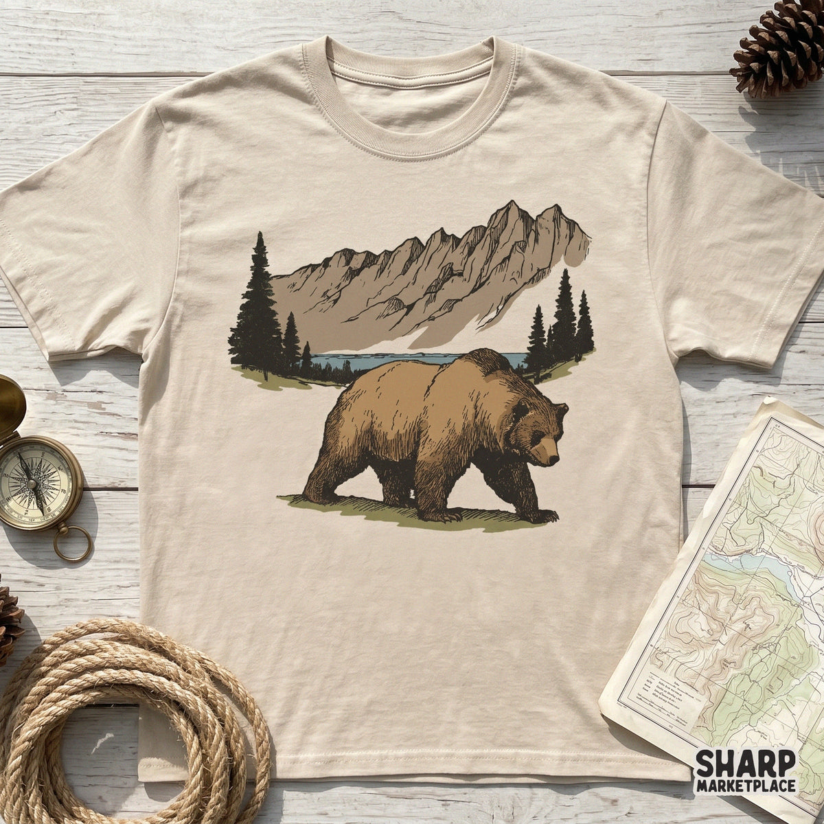 Hand-drawn grizzly bear walking along a forest path with alpine peaks, a versatile wildlife PNG for custom camping shirts and nature-inspired stickers.
