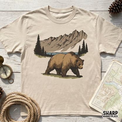 Hand-drawn grizzly bear walking along a forest path with alpine peaks, a versatile wildlife PNG for custom camping shirts and nature-inspired stickers.
