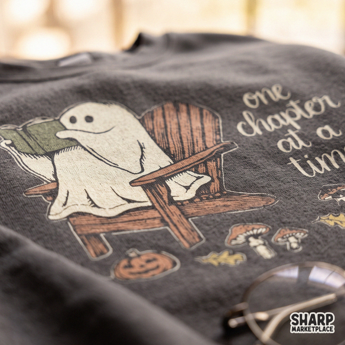 Cute ghost reading a book graphic PNG design for cozy fall and spooky season t-shirts
