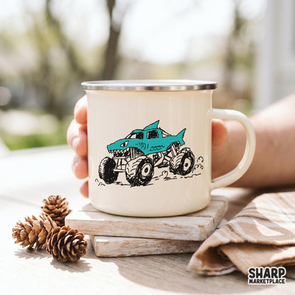 Cyan blue shark-themed monster truck graphic with rugged tires and sharp teeth, displayed on a cream-colored enamel mug for DIY print projects.