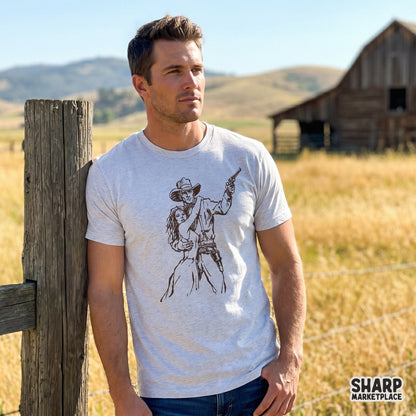 A rustic ink-style western design featuring a cowboy protecting a woman with a revolver, displayed as a graphic print on a light heather t-shirt.