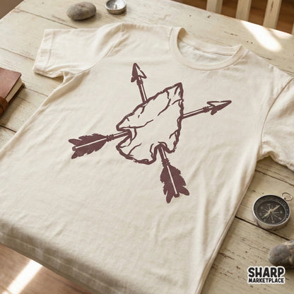 A rustic maroon arrowhead and crossed arrows graphic displayed on a cream colored t-shirt, perfect for western themed apparel and hunting inspired clothing.