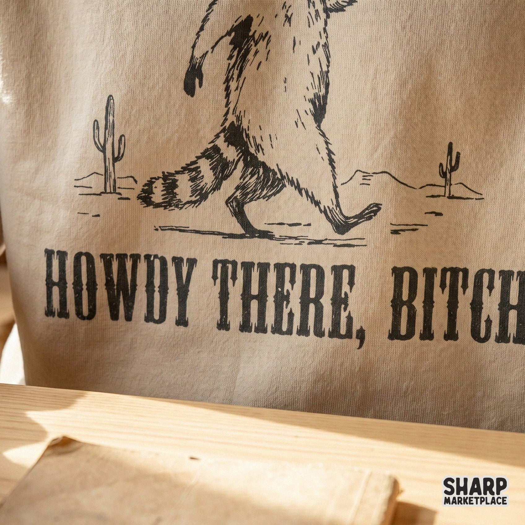 Western-style digital art of a walking raccoon in a desert landscape, featuring distressed typography for a retro aesthetic on shirts and DIY projects.