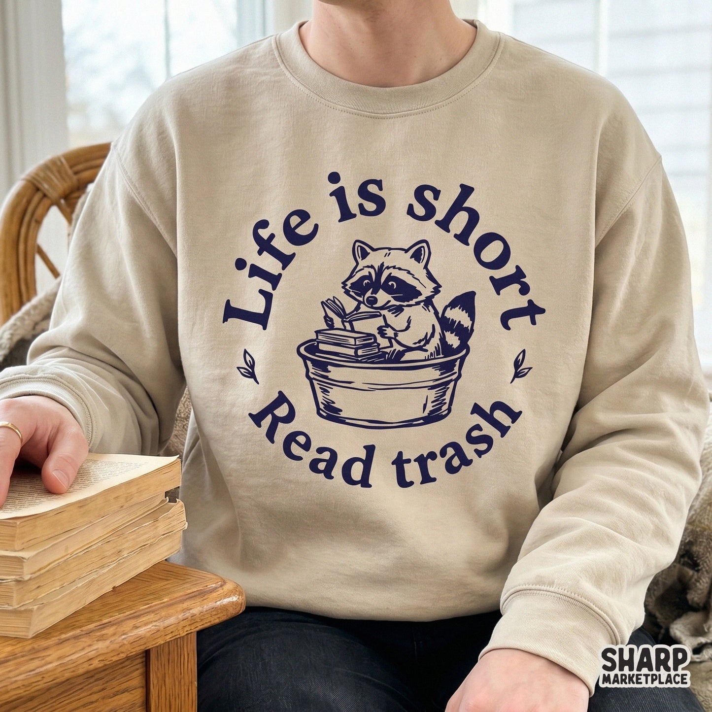 Funny reading raccoon graphic in a distressed navy blue ink style, perfect for sublimation, apparel, or stickers with the quote Life is short Read trash.