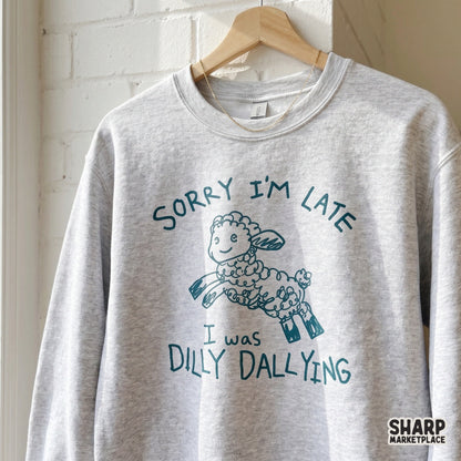 A heather gray sweatshirt featuring a whimsical teal sketch of a jumping sheep and the funny quote Sorry I'm Late I Was Dilly Dallying.