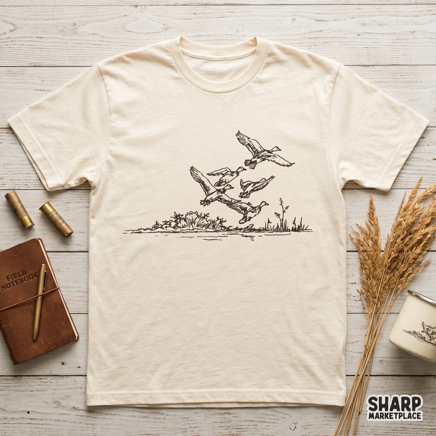 Detailed digital illustration of waterfowl in flight above a rustic reed line, designed for sublimation, stickers, or custom outdoor-themed apparel projects.