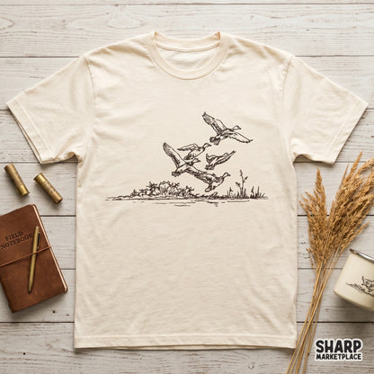 Detailed digital illustration of waterfowl in flight above a rustic reed line, designed for sublimation, stickers, or custom outdoor-themed apparel projects.