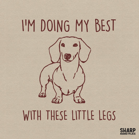 Hand-drawn maroon dachshund illustration with the text I'm Doing My Best With These Little Legs in a retro serif font on a neutral background.